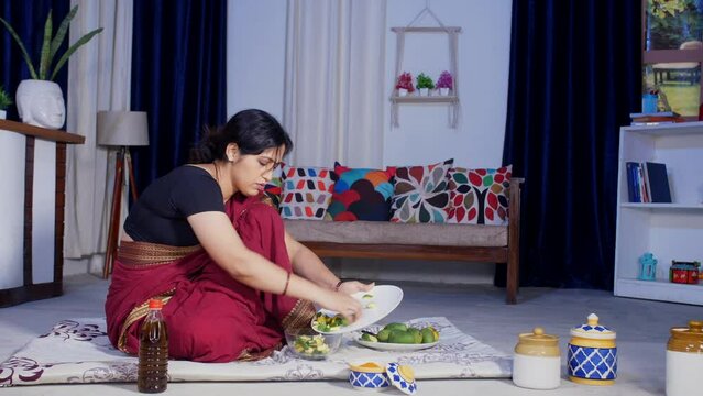 An Indian woman preparing raw mango pickle at home - pickle preparation  Indian condiments. An Indian housewife is working at home - domestic lifestyle  making Aachar   household work