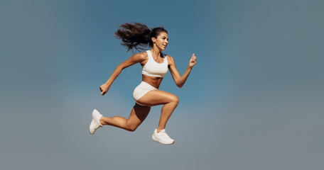 Active female athlete running mid air in a vigorous trining session. Generative AI.
