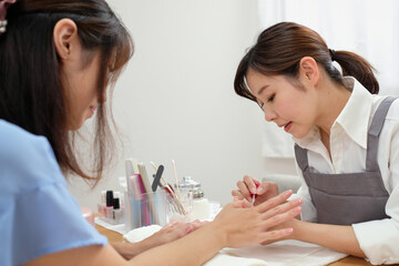 顧客に施術をするネイリスト