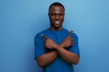 inspired young smart american man in t-shirt gesturing with hands on blue background with copy space