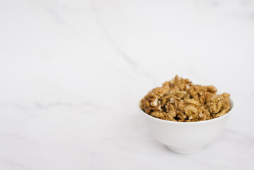 Walnut in a white bowl on a marble table