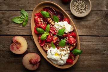 salade de tomates, pêches rôties, mozzarella burrata, basilic et graines
