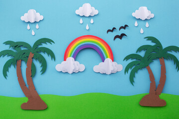 Rainbow on blue sky with clouds and coconut tree made of paper cut. creative minimal paper art concept.