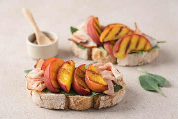 Peach prosciutto ham spinach bruschetta close up view. Delicious appetizer for wine