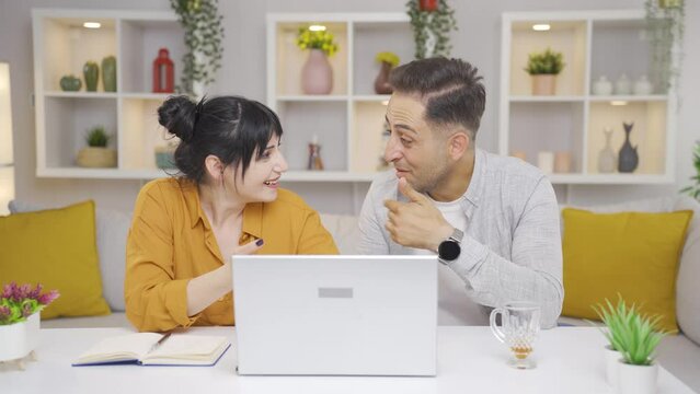 Couple confirming what they see on laptop.