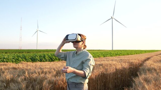 Farmer with VR glasses in corn field, wind turbines on the horizon
