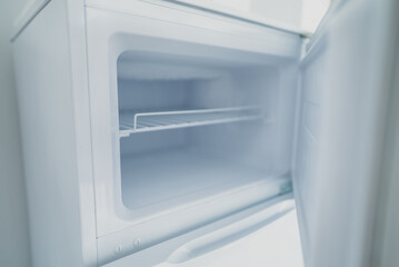 Empty open freezer in the refrigerator.