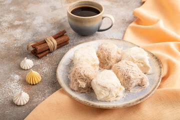 traditional arabic sweets pishmanie and a cup of coffee on brown concrete, side view.