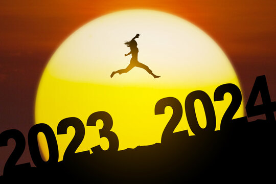 Silhouette Woman Jumping From 2023 To 2024 On The Hill At Sunset Or Sunrise