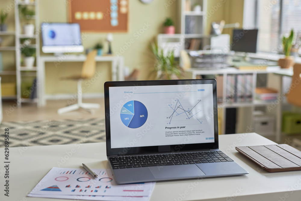 Poster background image of open laptop computer with statistics data graphs on screen in office workplace i