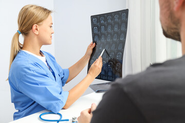 The doctor shows the tumor to the patient on MRI images of the head
