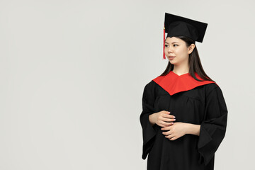 A girl of Asian appearance, a college graduate, on a gray background