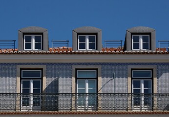 Windows and tiles of a building in Lisbon, Portugal, against the blue sky
