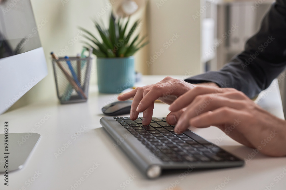 Aufkleber closeup of male hands typing on wireless keyboard while using computer at office workplace, copy spa