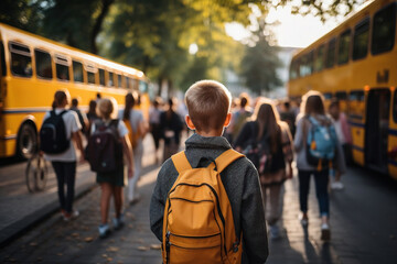 A school-aged boy dressed in his favorite t-shirt wanders toward the school bus. Warm sunny day. Back to school. Fictional person. Generated Ai