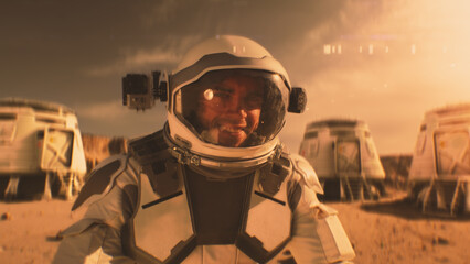 Astronaut in spacesuit smiles, looks at camera. In the background research station or scientific...