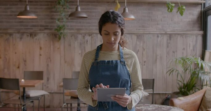 Portrait of Waitress in Bar Restaurant, using Digital tablet and Looking at camera