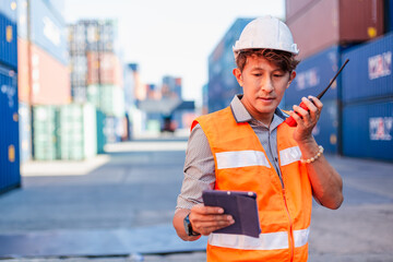 Foreman using radio walkie talkie control loading containers box in cargo for import export, Professional engineer work checking loading containers box.