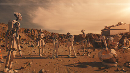 Two astronauts in spacesuits talk, stand on Mars surface with robots. AI powered rover in the background. Manned exploring space mission. Red planet. Futuristic colonization and exploration concept. © Framestock