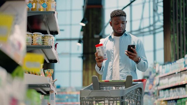 African American man takes packaged item from store shelf