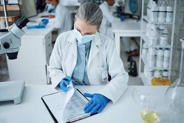 Senior woman, scientist and lab writing for research and notes for medical analysis. Info, investigation and laboratory documents for covid and healthcare report with paperwork and data planning