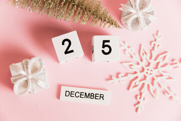 Flatlay, Christmas decoration and calendar with date December 25 on pink paper background with copy space. Christmas and New Year celebration concept.