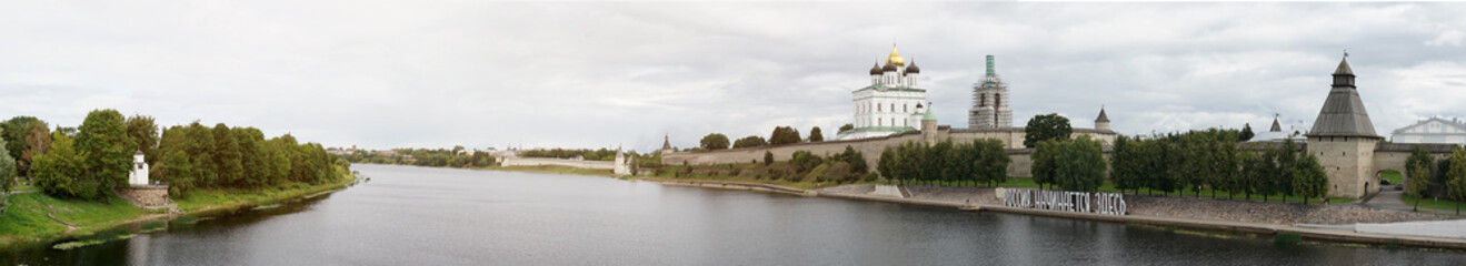 Fototapeta na wymiar Panorama. View of the Pskov Kremlin from the bridge to the river.