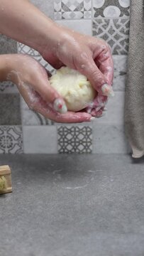 Mujer lav&aacute;ndose las manos con una pastilla de jab&oacute;n natural en una ducha con alicatado de azulejo
