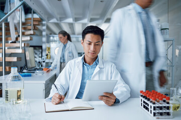 Asian man, tablet and writing in science laboratory for medical virus research, medicine and vaccine development. Busy scientist, technology and notebook paper for blood sample healthcare or wellness