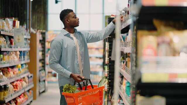 African American man with basket chooses product in store