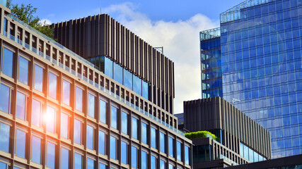 Obraz premium Glass modern building with blue sky background. View and architecture details. Urban abstract - windows of glass office building in sunlight day.