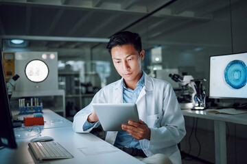 Tablet, planning and scientist with digital innovation, data and reading in laboratory. Asian man,...