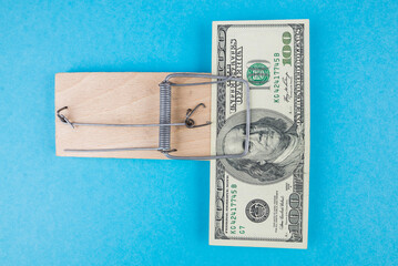 dollar in a mousetrap on a blue background.