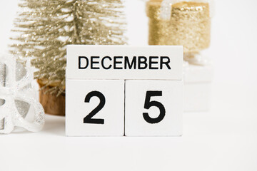 Christmas, wooden calendar with the date December 25 and decor on a white background. The concept of preparing for the Christmas and New Year holidays.