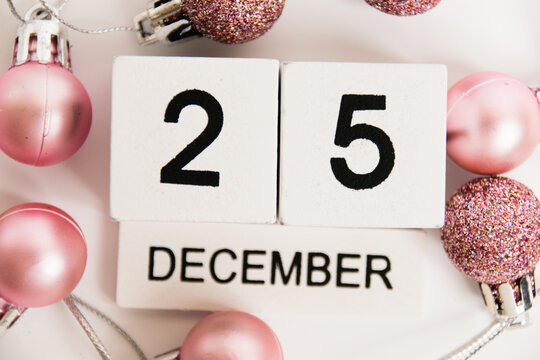 Christmas, wooden calendar with the date December 25 and decor on a white background. The concept of preparing for the Christmas and New Year holidays.