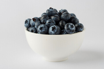 bowl with blueberries on a white background, close, horizontal, macro.