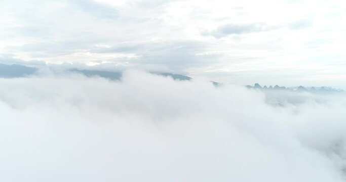 Aerial photography of cloud-shrouded karst peaks. Located near Yangshuo County, Guilin City, Guangxi Province, China