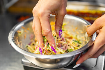 woman hand cooking cabbage coleslaw salad in bowl