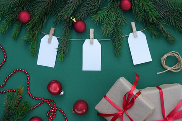 Christmas paper gift tags with fir tree branches, pine cones and holiday decorations with presents. Rustic winter composition with blank Gift tags Mockup.Top view, flet lay, close up. © Photo
