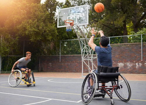 Sports, basketball and men in wheelchair for goal in training, exercise and workout on outdoor court. Fitness, team and male people with a disability shoot ball for competition, practice and games - Powered by Adobe