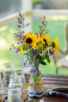 DIY wedding flower arrangement on table with wild sunflowers and purple forget-me-not tree flowers