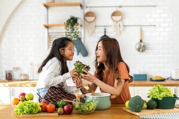 Portrait of enjoy happy love asian family mother with little asian girl daughter child help cooking...