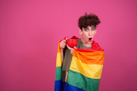 lgbt culture. Funny guy doing makeup. Pink background.
