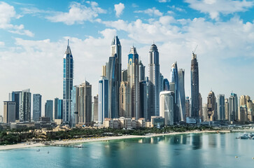 Fototapeta na wymiar The Palm Jumeirah archipelago opens the view on the coast of the mainland with sand beaches and skyline of Dubai Media City and Dubai Marina with skyscrapers, Dubai, UAE
