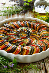 Provençal tian, traditional vegetable casserole with aromatic herbs, close-up view