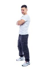 A smiling man is standing in a white tank top and blue casual trousers. Positivity and success. Isolated on a white background. Vertical.