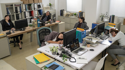 top angle shot of group of exhausted asian businesspeople taking naps in a modern office at company.