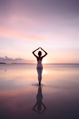 Young girl practising yoga on a beach during sunrise