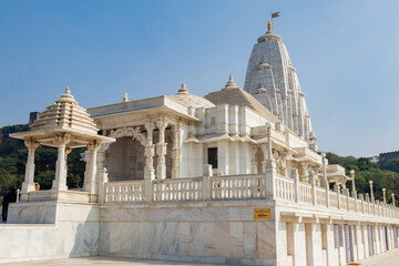 Low angle wide view of Birla temple made with marble and. blue sky in the background for Hinduism...
