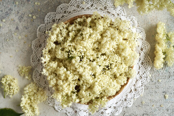 Elderberry flowers in a wicker basket, top view